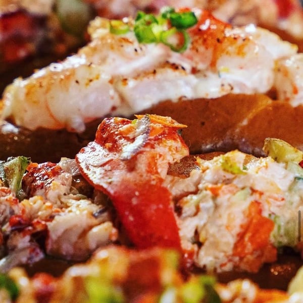 Close-up of Lobster & Beer NASA's lobster rolls, with succulent lobster meat and vibrant garnishes.