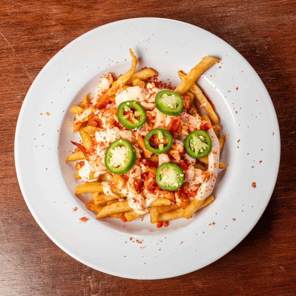 Lobster & Beer NASA's fries topped with lobster, sauce, red spice, and jalapeño slices.
